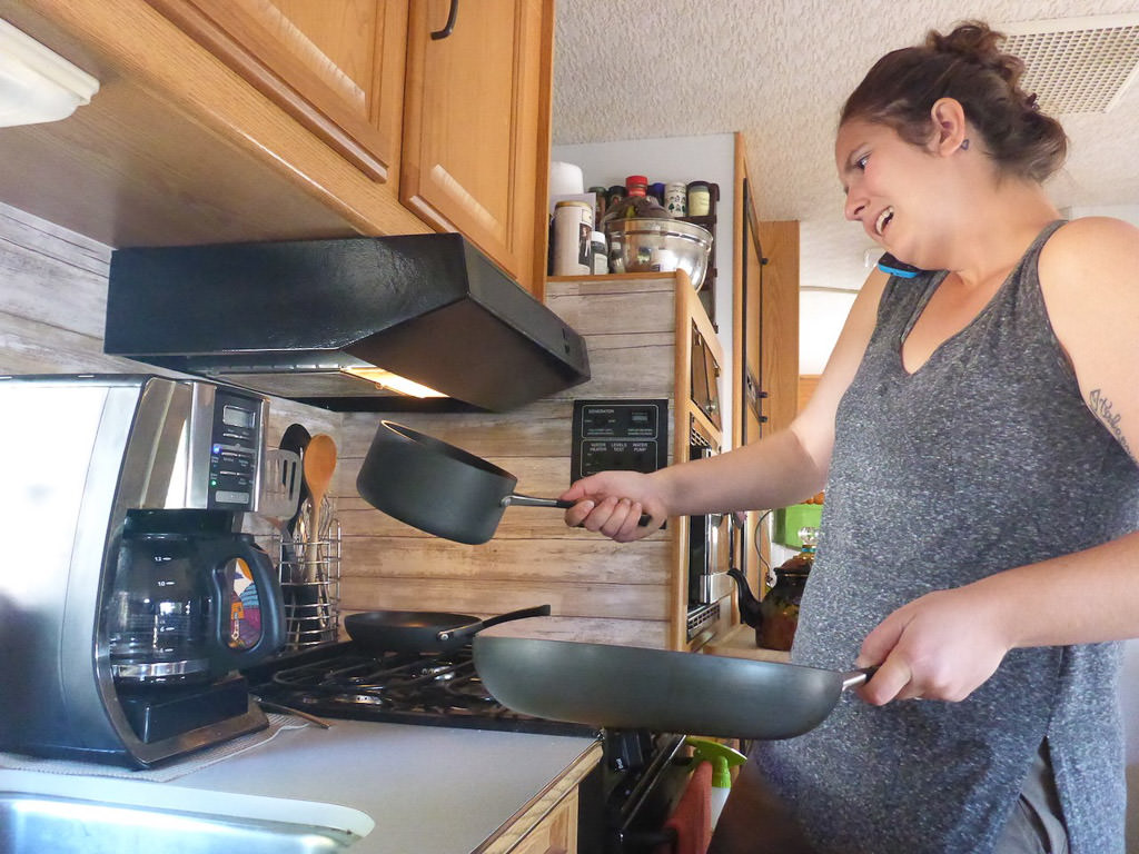 Melanie talking on the phone while cooking on the stovetop.
