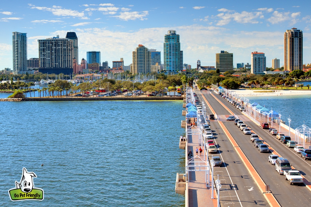 Cars parked on bridge over water leading into the city