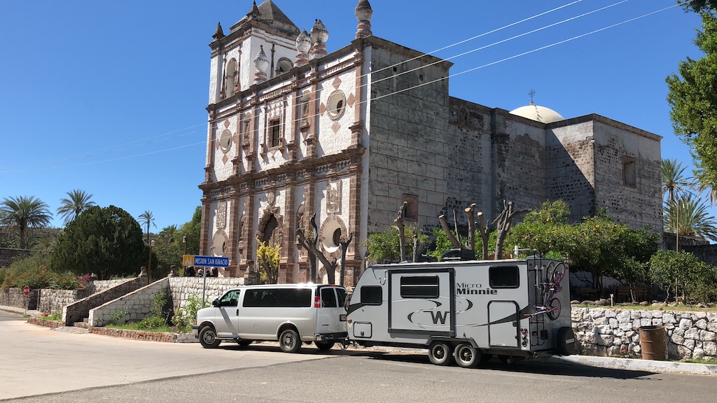 White passenger van pulling Micro Minnie pulled over on side of road 