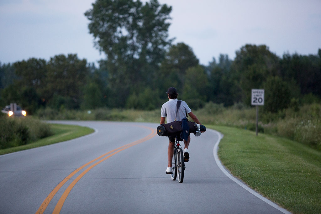 Jordan on a bike with golf clubs on his back