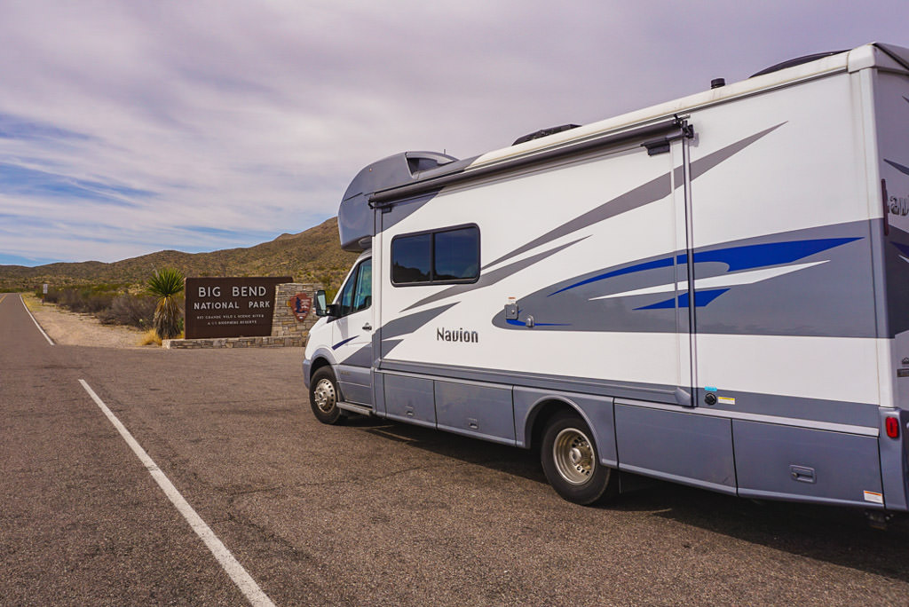 Winnebago Navion parked in front of the sign for Big Bend National Park
