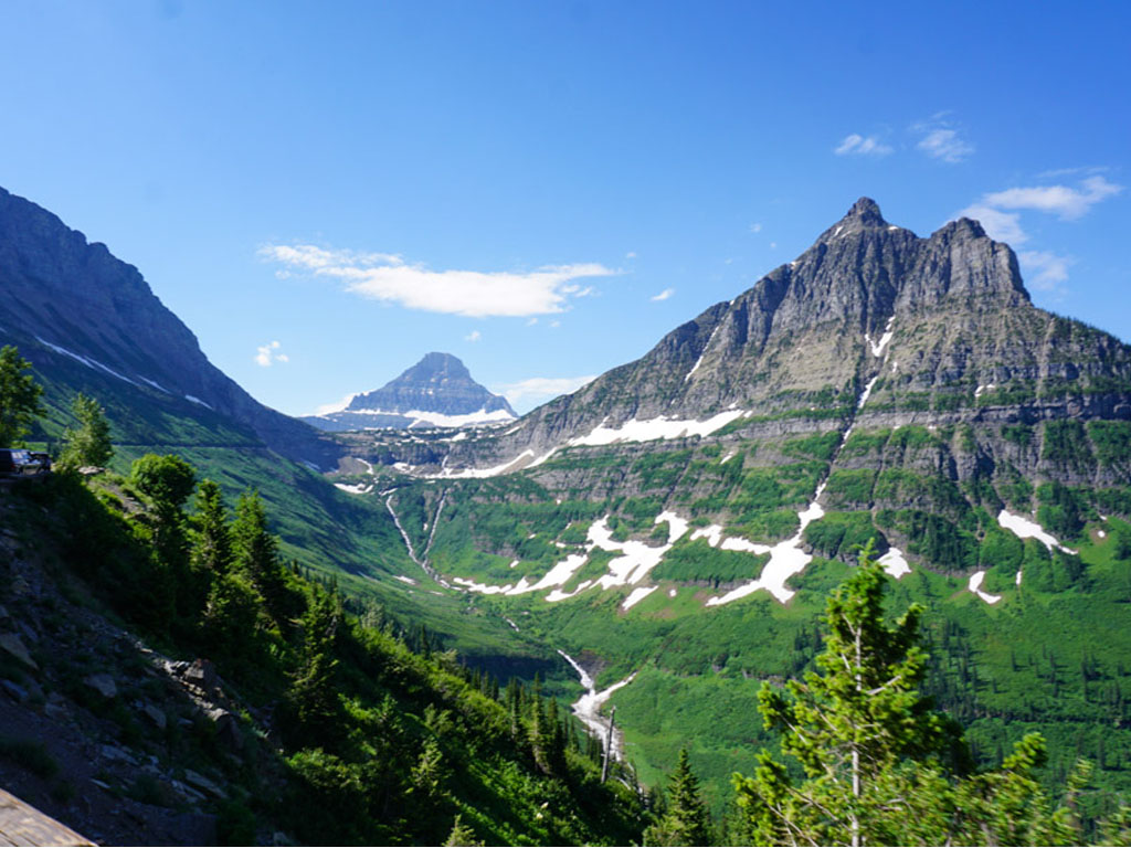 Towering mountains with green valley and river running below