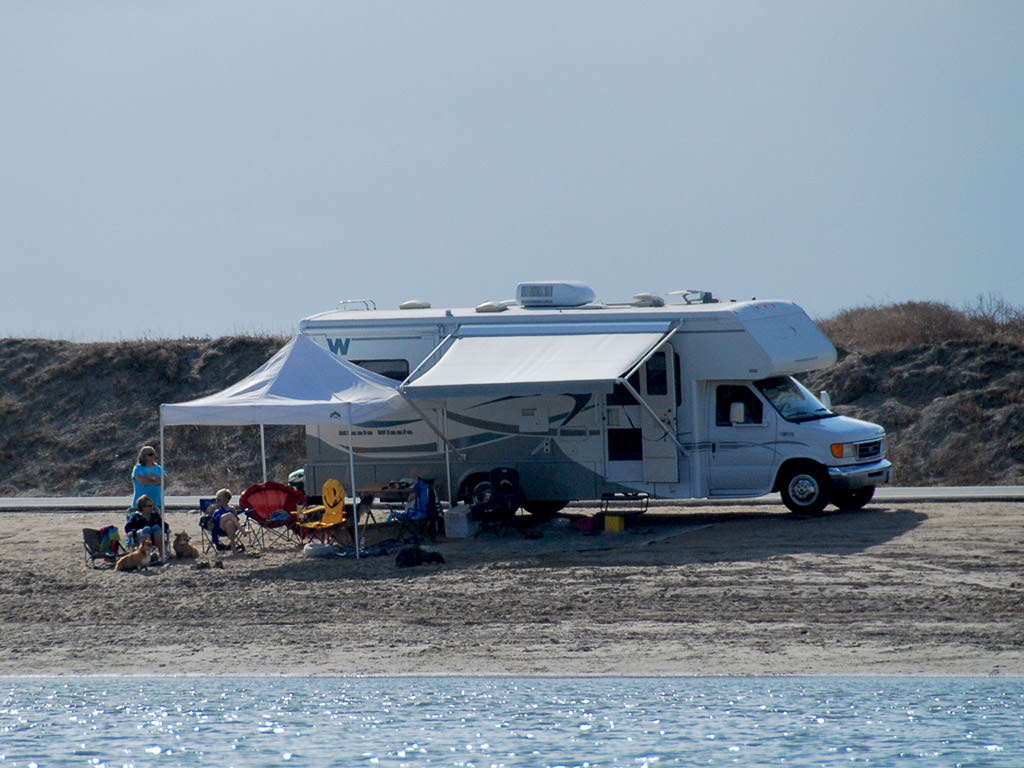 Lafleur family sitting outside of Vista LX under two white tents next to water