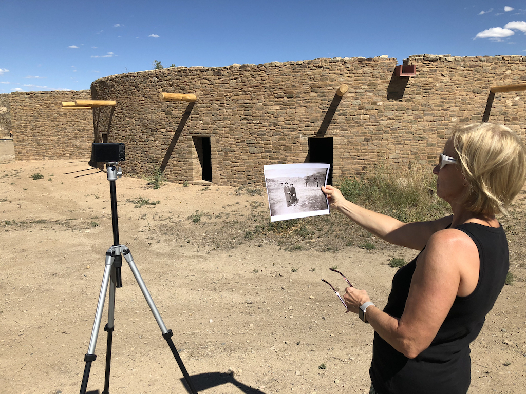 Don's wife holding the old photo trying to line up where to have the camera point to recreate the image.