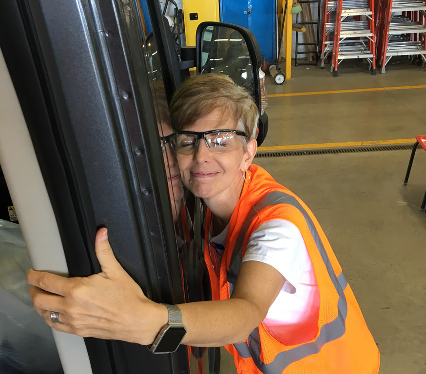 Woman hugging the side of a motorhome.