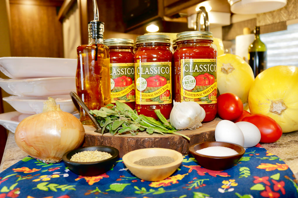 Three cans of spaghetti sauce and bowls of seasoning on the counter