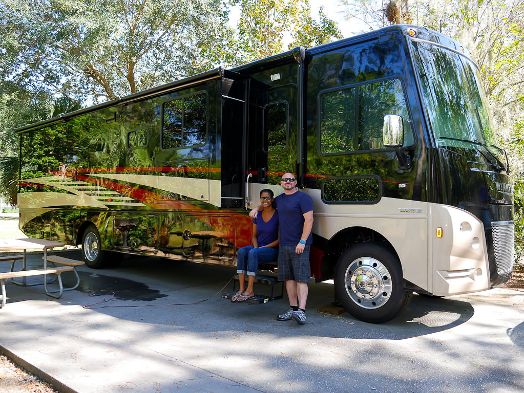 Kenny and Sabrina outside the parked Winnebago Adventurer.