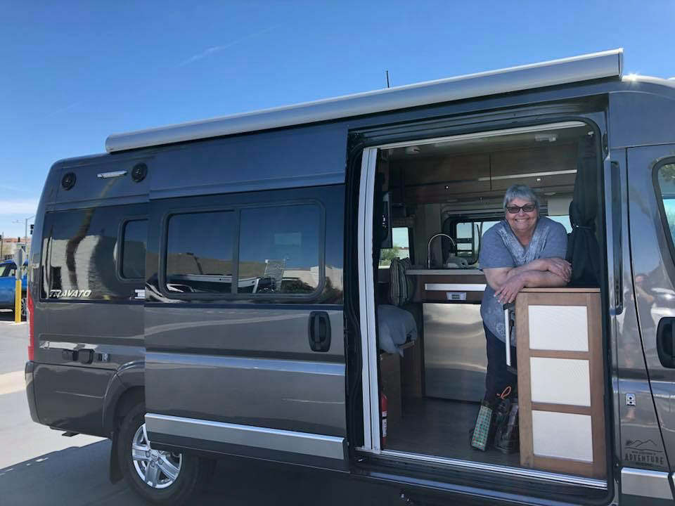 Sue Ann standing in Travato smiling for camera