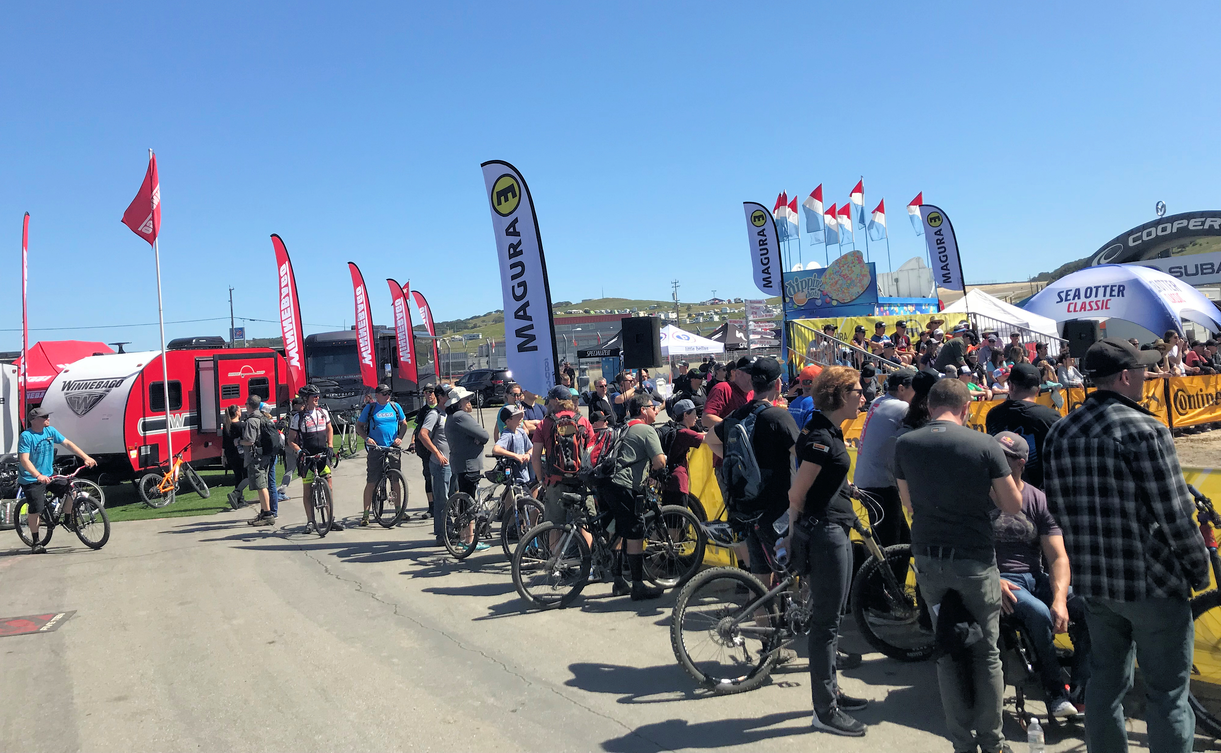 Spectators watching an event. Winnebago booth is in the background