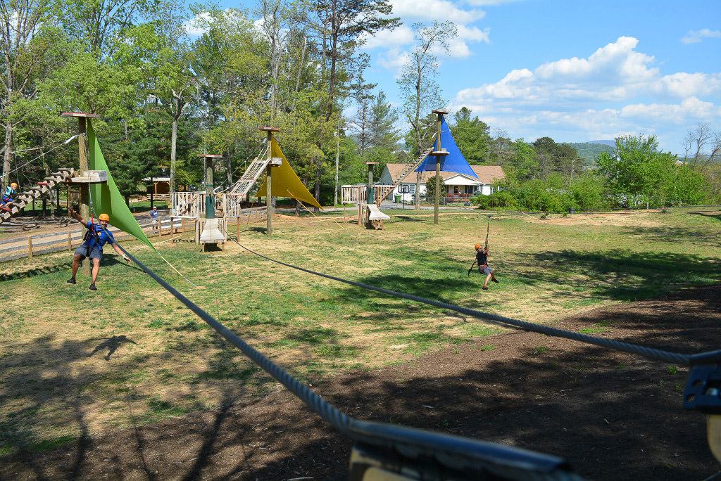Adventure center with 2 people going down ziplines.