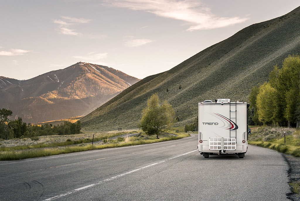 Winnebago Trend pulled to side of the road with tall hillsides ahead.