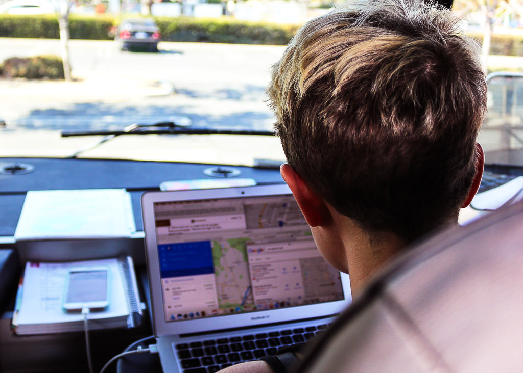 Young woman using computer to download map directions