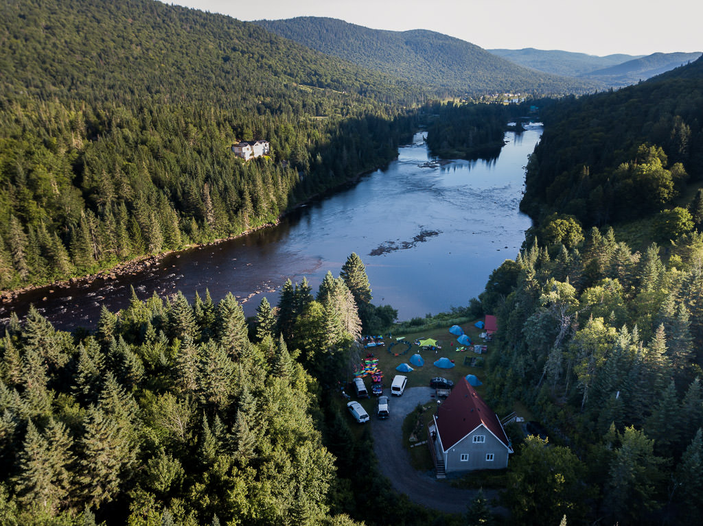 Tents set up at the edge of a river.