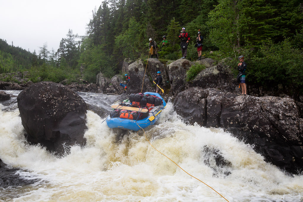 Raft with all the group's supplies being lined down the rapid.