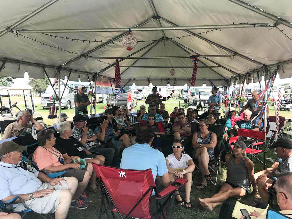 GNR attendees gathered socializing under a tent.