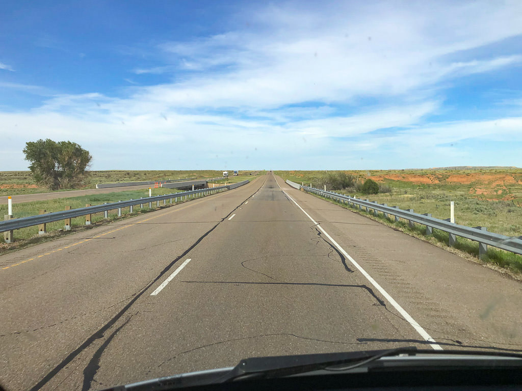 Open road ahead with plains on either side.