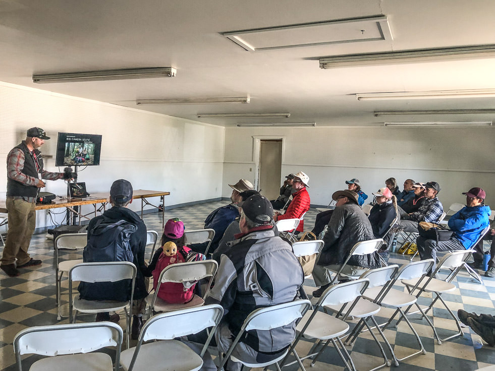 Small group gathered listening to a speaker.
