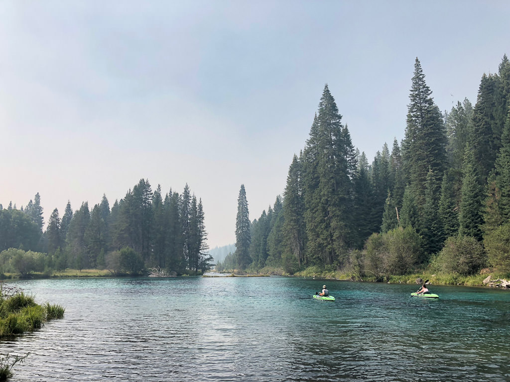 Kayakers using inflatable kayaks paddle down a body of water