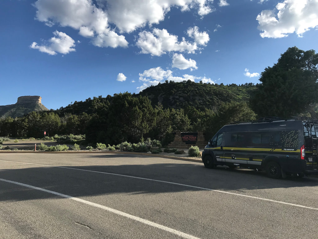 Winnebago Travato parked with a cliff in view at Mesa Verde National Park