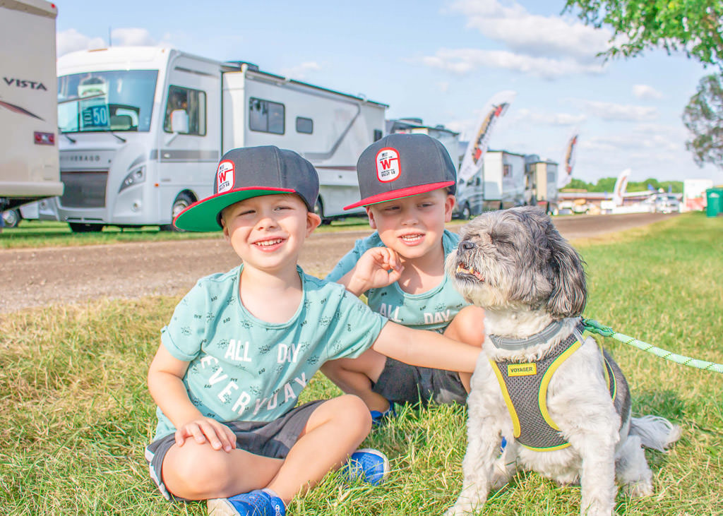 The boys petting a dog outside the Winnebago product display
