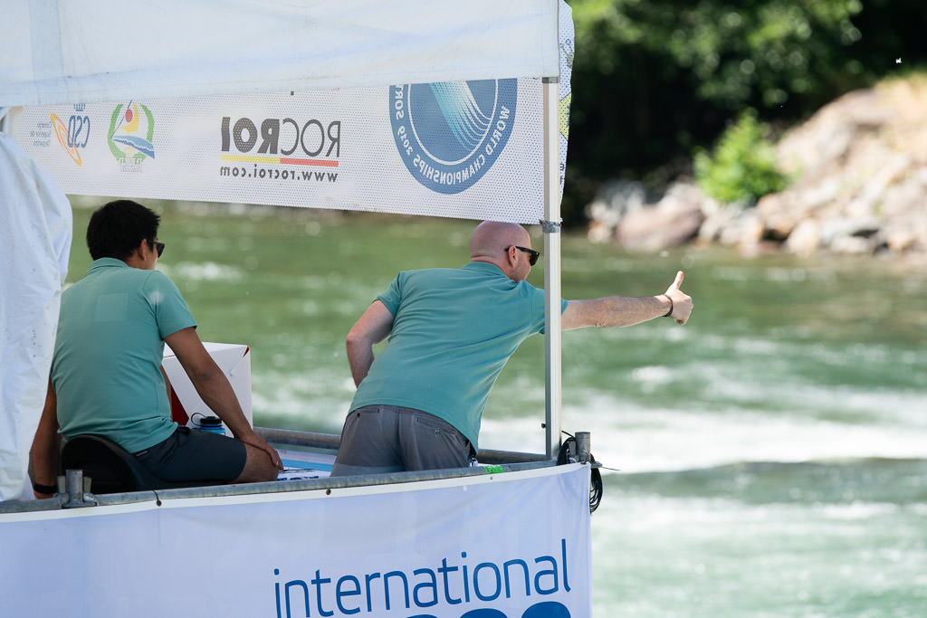 Judges signaling to kayakers from a lookout.
