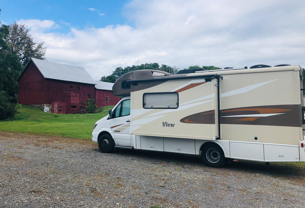 Parked Winnebago View with a red barn in the background.