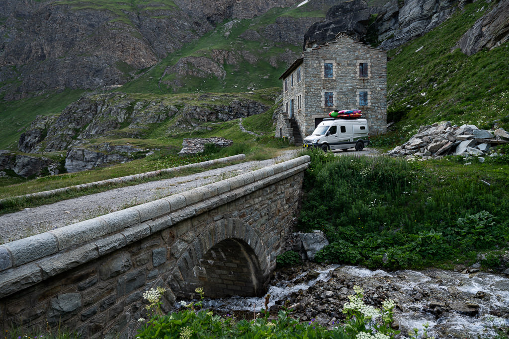 Winnebago Revel about to cross bridge with old building in background.